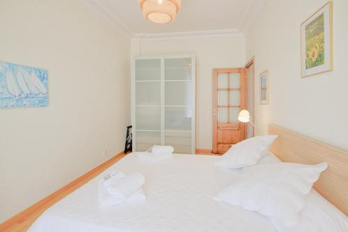 a bedroom with a white bed with white pillows at le capitole in Nice