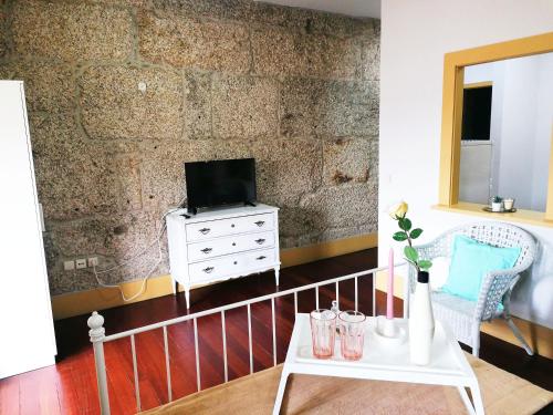 uma sala de estar com uma televisão e uma mesa branca em 4-As center apartments em Guimarães