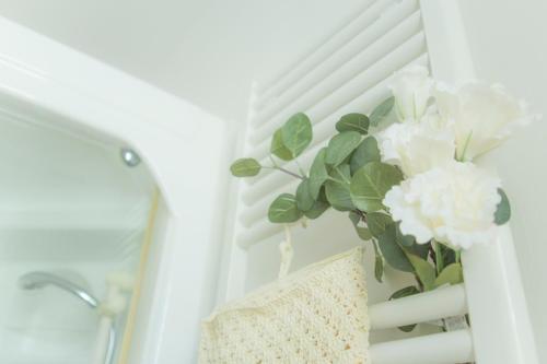 un vaso con fiori bianchi su una scala di Sirena Apartment a Riccione