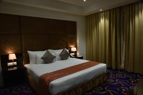 a bedroom with a large bed in a hotel room at Pride Hotel & Convention Centre Indore in Indore