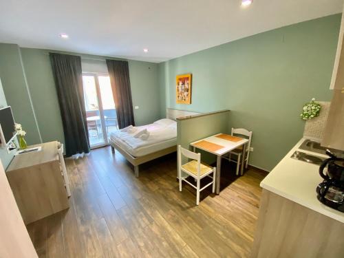 a small room with a table and a bed and a kitchen at Iris Studios in Umag