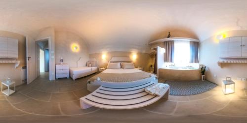 1 dormitorio grande con 1 cama grande y bañera en Dimora Sighé, esclusiva villa di design con piscina privata idromassaggio in Puglia, en Alessano