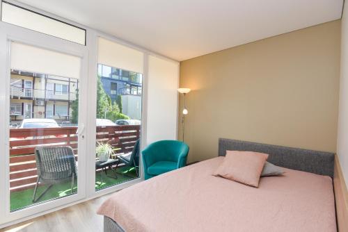 een slaapkamer met een bed en een balkon met een tafel bij K36 in Juodkrantė