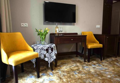 a room with a table and two chairs and a tv at Dworek Jamneński in Łazy