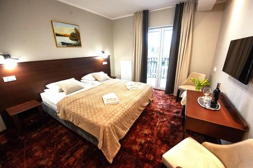 ワジにあるDworek Jamneńskiのベッドとテレビが備わるホテルルームです。