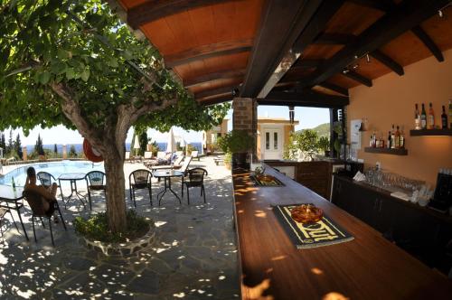 a bar with a table and chairs and a tree at Dina's Paradise in Agios Gordios