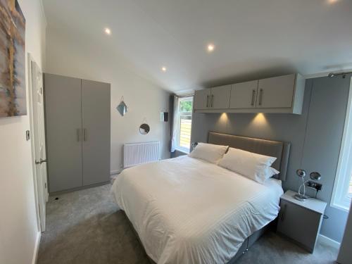una camera da letto con un grande letto con lenzuola bianche di Fox Lodge at Owlet Hideaway - with Hot Tub, Near York a York