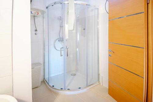 a shower with a glass door in a bathroom at Apartments Apartim Piran in Piran