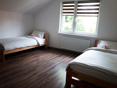 a bedroom with two beds and a window at Apartament w Milówce in Milówka