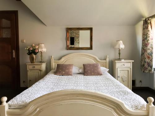 a white bed with two pillows and a mirror at Willa A.D.1894 in Łeba