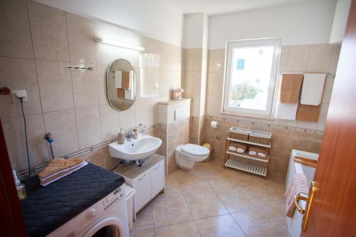 a bathroom with a sink and a toilet and a window at Apartment Jerry with private pool in Milna