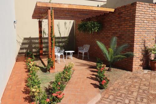 a patio with a table and chairs and flowers at Ville Park Hotel in Ourinhos