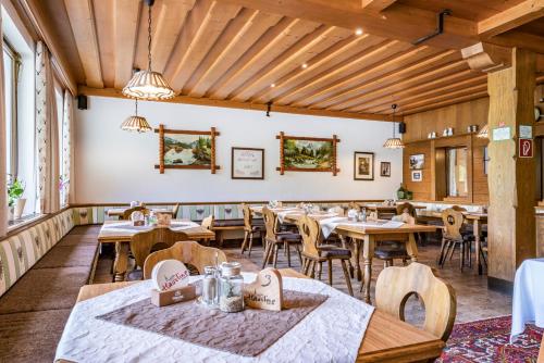 comedor con mesas y sillas de madera en Gasthaus Häusling Alm, en Mayrhofen
