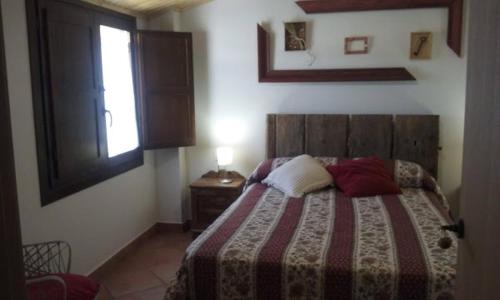 a bedroom with a bed and a window and a window at Apartamentos Plan Dulcis in Buera