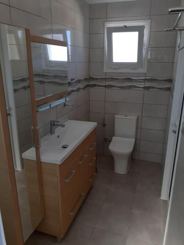 a bathroom with a toilet and a sink and a mirror at Your Second Home in Kefalos
