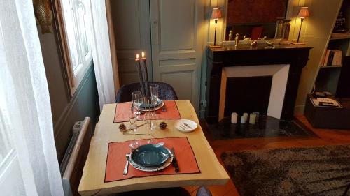 - une table avec une bougie et une plaque dans l'établissement Le repaire de Rougemare déco soignée et chaleureuse, centre historique, à Rouen