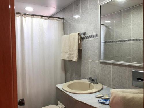 a bathroom with a sink and a toilet and a mirror at Hotel Sol del Pacifico in Lázaro Cárdenas
