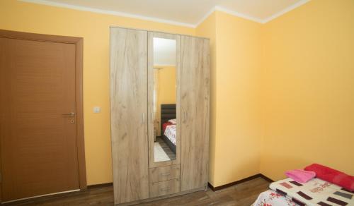 a room with a wooden cabinet with a mirror at Apartment Milena in Virpazar