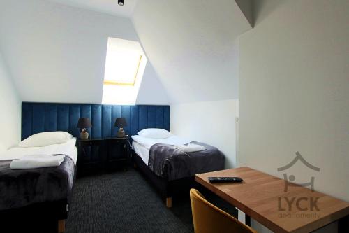 pokój hotelowy z dwoma łóżkami i stołem w obiekcie Lyck Apartamenty w mieście Ełk