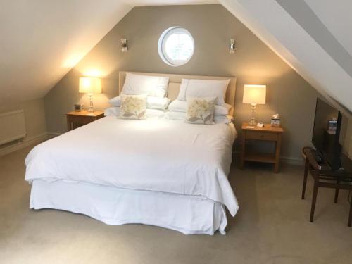 una camera con un letto bianco e una finestra di College View a Cheltenham
