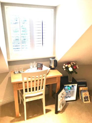a table and chair in a room with a window at College View in Cheltenham