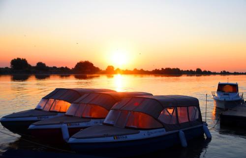 two boats are docked in the water at sunset at Hotel Sunrise in Crisan