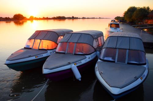 three boats are docked in the water at sunset at Hotel Sunrise in Crisan