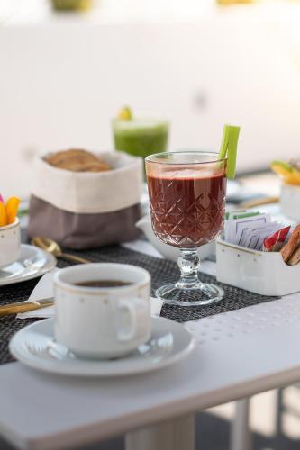 a table with a drink and two cups of coffee at Hotel Boutique Maria in Morelia
