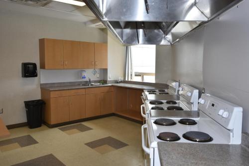 a kitchen with a stove top oven in a room at Residence & Conference Centre - London in London