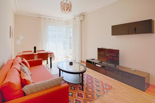 ein Wohnzimmer mit einem roten Sofa und einem TV in der Unterkunft le capitole in Nizza