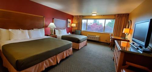 a hotel room with two beds and a flat screen tv at Olympic View Inn in Sequim