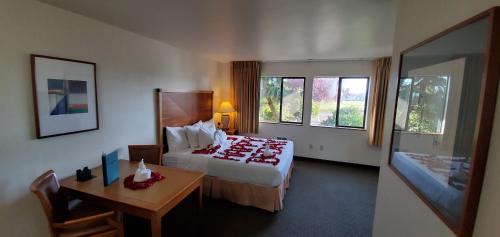 una camera d'albergo con letto, tavolo e scrivania di Olympic View Inn a Sequim
