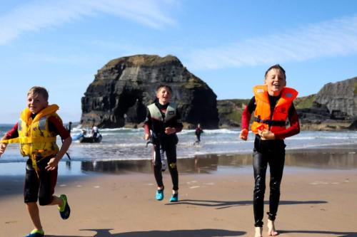 a group of three people running on the beach at McMunns of Ballybunion in Ballybunion