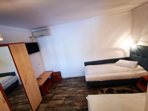 a small room with two beds and a mirror at Hotel Sunrise in Crisan