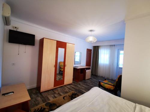 a hotel room with a mirror and a bedroom at Hotel Sunrise in Crisan
