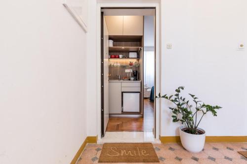 a hallway with a small kitchen and a rug with a plant at Promenade Room Split **** in Split