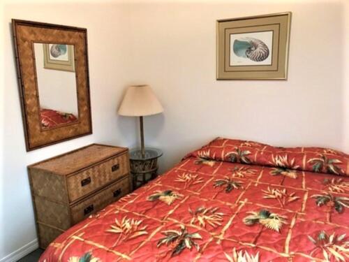 1 dormitorio con cama, tocador y espejo en Village by the Gulf, en Gulf Shores