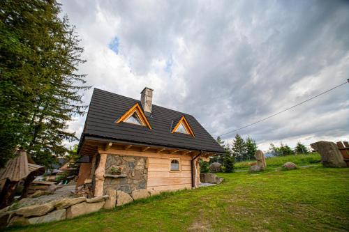 a small cabin with anadobe roof on top of it at Domki u Bobaków in Ząb