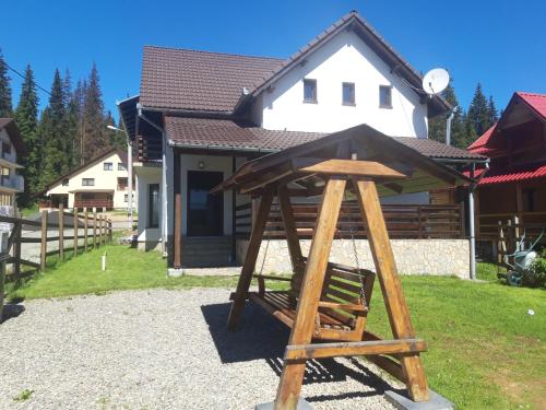 a wooden stand in front of a house at CABANA DORULUI in Tău Bistra