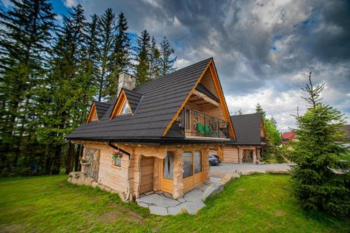 a large log cabin with a black roof at Domki u Bobaków in Ząb