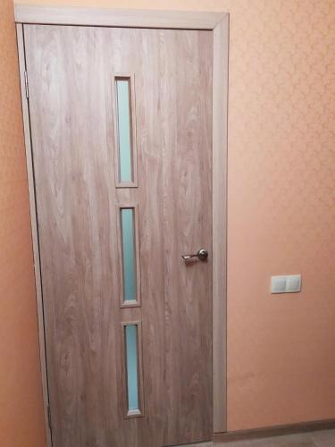 a wooden door with a window in a room at Filatov apartment in Odesa