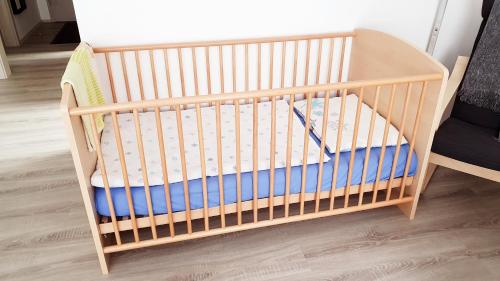 a wooden crib in a room with a table at Sam's Place in Kreuzwertheim