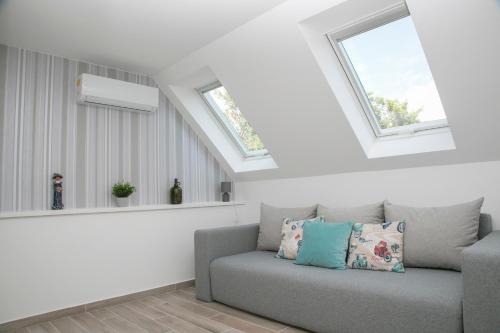 a living room with a couch and two windows at Kardos Villa in Szigliget