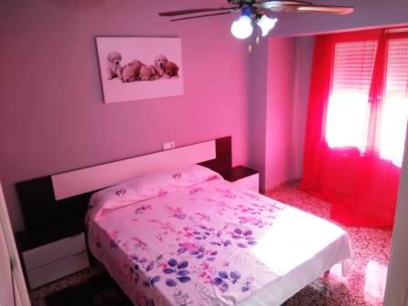 a pink bedroom with a bed and a ceiling fan at Torrevieja Playa Cura in Torrevieja