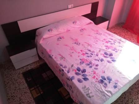 a bedroom with a pink bed with flowers on it at Torrevieja Playa Cura in Torrevieja