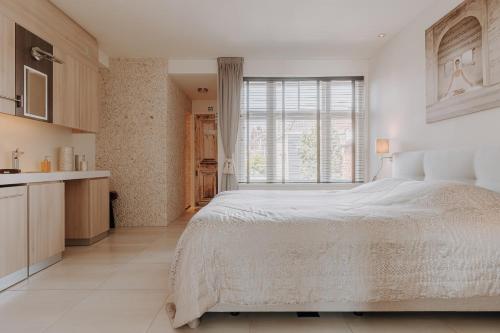 Un dormitorio blanco con una cama grande y una ventana en ZEN b&b en Dordrecht