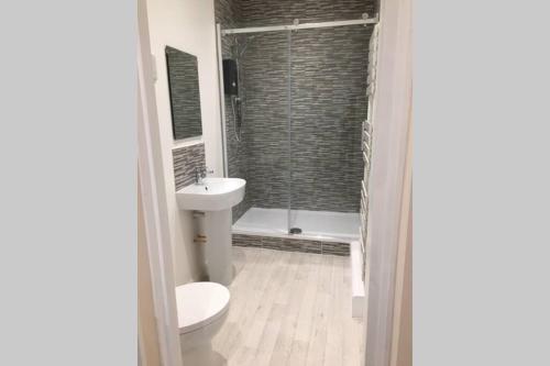 y baño con aseo, lavabo y ducha. en Private 1st Floor Apartment - Perfect for Port of Dover, Eurotunnel and Short Stays en Dover