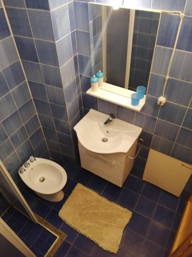 a blue tiled bathroom with a toilet and a sink at Villetta La Bluette Capo Vaticano in Capo Vaticano