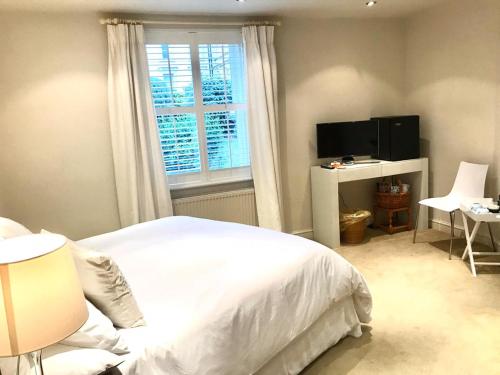 a bedroom with a white bed and a window at College View in Cheltenham