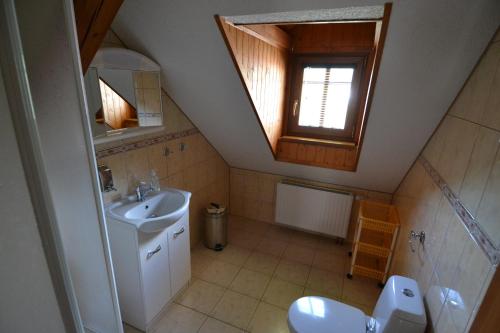 a bathroom with a sink and a toilet and a window at Penzion "U Krkovičky" in Brtníky